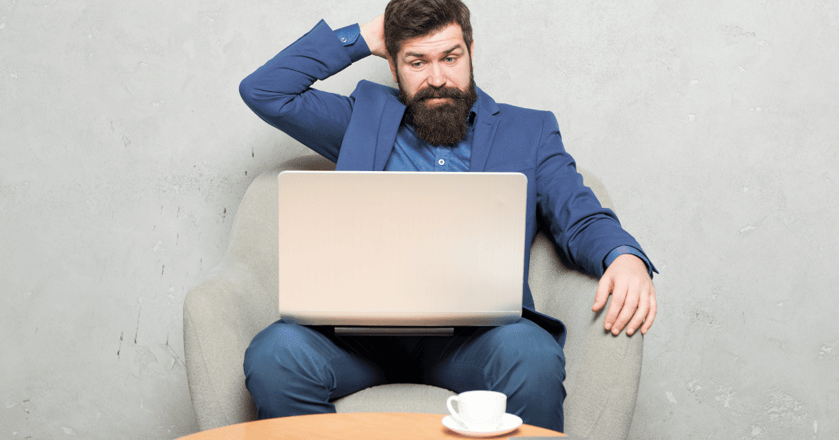 Hombre con cara de frustración pensando en la estructura de un blog en un portátil
