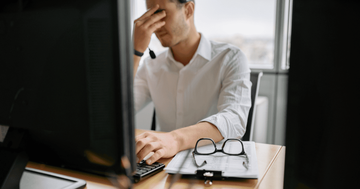 Hombre profesional con gesto de frustración frente a su ordenador por un error invisible en su página web que afecta a su negocio.